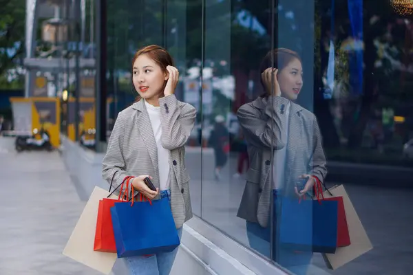 아시아 웃으며 색깔의 쇼핑백 전화를 쇼핑센터 섭니다 — 스톡 사진