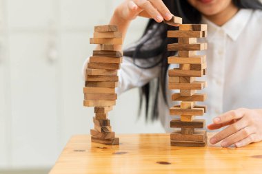 Kızın eli, kuleyi devirmeden tahta bloğu sökmeye çalıştı. Yetenek grubu oyunu İnşaat işi risk konsepti. Yanındaki metin için yeri olan yakın plan fotoğraf.