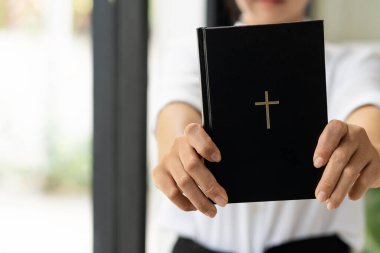 Siyah derili, elinde Hıristiyan haçı olan, kalbinde İncil 'i tutan siyahlı bir kadın. Dini kavramlar ve tatiller