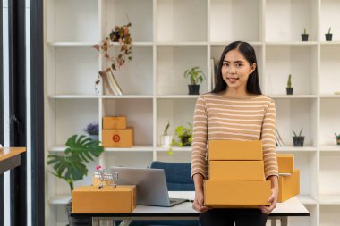 Ev bilgisayarında çalışan Asyalı bir kadın müşterilerden emir almak için internetten bilgisayar başında çalışıyor..