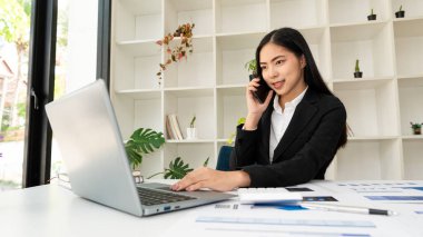 Bilgisayarda çalışan Asyalı iş kadını finansal grafikleri analiz ediyor finansal istatistikler kar büyütme fikri