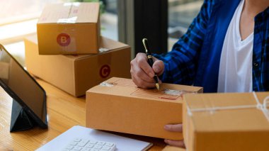 Girişimci, küçük işletme, KOBİ, serbest çalışma. Ticari denetimler için bir dizüstü bilgisayar kullanın. çevrimiçi pazarlama paketleme kutusu KME satıcı e-ticaret konsepti çevrimiçi satış ekibi