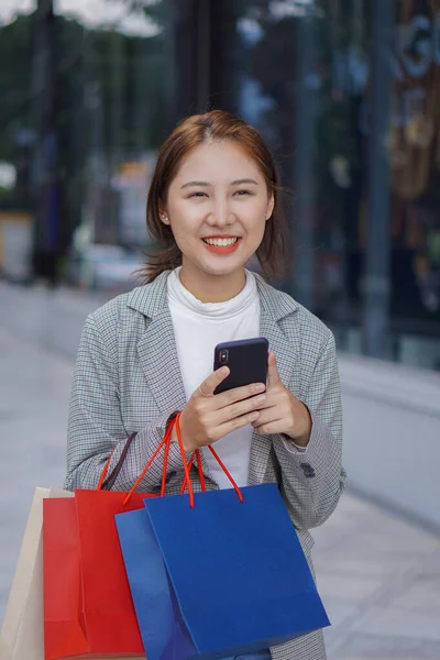 在购物中心提着购物袋的亚洲女人购物愉快 — 图库照片