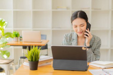 Asyalı kız online alışveriş tableti kullanarak online alışveriş yapıyor. Kredi kartı, akıllı telefon, akıllı ödeme, para transferi teknolojisi kullanıyor.