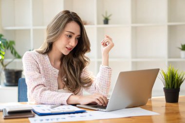 Ofiste dizüstü bilgisayarda çalışan güzel bir Asyalı kadın. Finansal istatistik veri analizi grafiği büyüyen iş dünyası fikrine bakan iş kadını