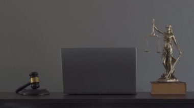 Bilgisayar yargıcı çekiç kitapları ve terazileri avukatın hukuk danışma masasında adalet tanrıçası..