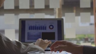 Finans muhasebesinde çalışan Asyalı bir kadın dizüstü bilgisayarla iş konsepti tablosunun hesaplama analizinde doküman çiziyor..