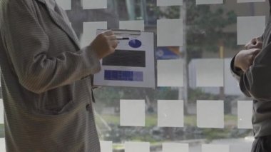 2Asyalı iş adamı, iş konsepti tablolarının hesaplama analizinde dizüstü bilgisayarla ve grafik belgeleriyle ofiste mali muhasebe üzerinde çalışıyor..