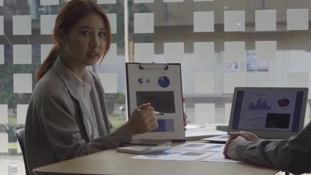 ラップトップとオフィスで財務会計に従事するアジアの女性ビジネスコンセプトテーブル上の計算分析の文書をグラフ化 — ストック動画