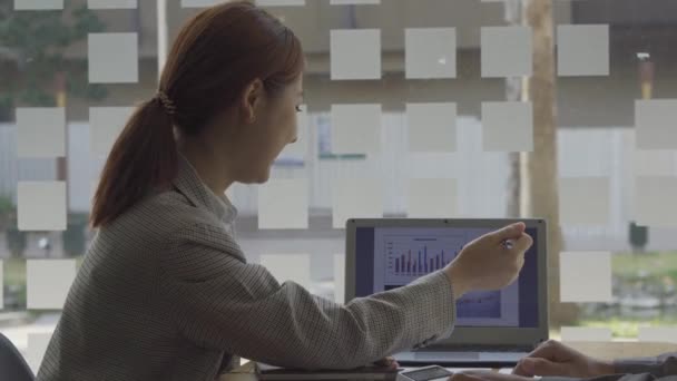 ラップトップとオフィスで財務会計に従事するアジアの女性ビジネスコンセプトテーブル上の計算分析の文書をグラフ化 — ストック動画