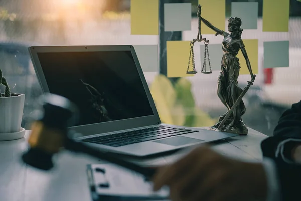 Lawyer's Office Scales of the Goddess of Justice Lawbook and lawyer page. Law concept. Judge's hammer, old courtroom library. Wooden table.