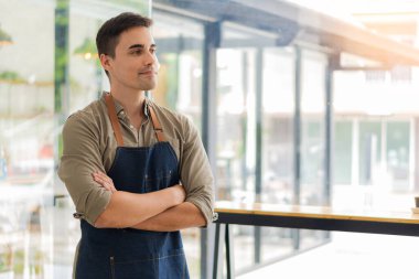 Lokantada genç bir adam kollarını masada kavuşturmuş bir işadamı..