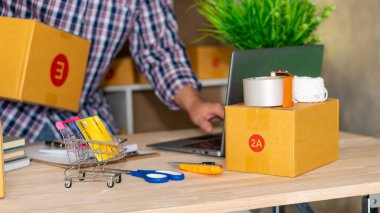 İşte kutularla ve laptoplarla çalışan Asyalı bir KOBİ 'nin portresi. Küçük işletme sahibi Girişimcilik, küçük işletme, KOBİ ya da serbest işletme kurma İnternet üzerinden ve dağıtım fikirleri.