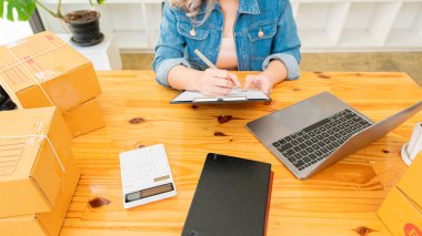 İşte kutularla ve laptoplarla çalışan Asyalı bir KOBİ 'nin portresi. Küçük işletme sahibi Girişimcilik, küçük işletme, KOBİ ya da serbest işletme kurma İnternet üzerinden ve dağıtım fikirleri.