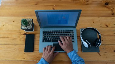 Akıllı telefon ve kulaklıkla klavye yazan işadamlarının üst görünümü