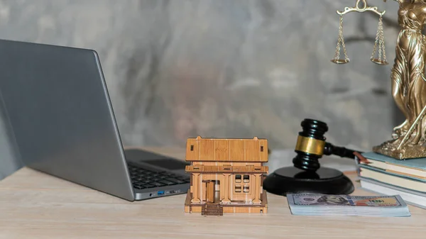 financial approval concept Scales of the Goddess of Justice Real Estate Law and Auction Ideas Judge's hammer with house, money, and laptop on the table.