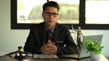 Adalet ve hukuk kavramı. Bir erkek avukat, ahşap bir masanın üzerinde pirinç ölçekli bir tanrıçayla bir ofiste çalışır. Laptop Hukuki Konseptleri ve Hukuk Hizmetleri ile Adalet Çekici