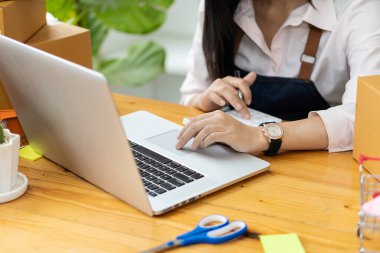 Evde çalış. İnternette ürün satmak. Küçük işletme sahibi, masasındaki dizüstü bilgisayarlarla ve Asya 'daki odasında posta kutularıyla işe başlıyor..