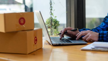 Evde çalış. İnternette ürün satmak. Küçük işletme sahibi, masasındaki dizüstü bilgisayarlarla ve Asya 'daki odasında posta kutularıyla işe başlıyor..