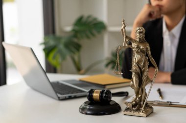 Gail Brass ile birlikte ofiste. Adalet heykeli ve avukat dizüstü bilgisayarda ve kadın yargıcın çekiciyle ya da Eustitia 'yla çalışıyor. Roma adalet tanrıçası, hukuki kavramlar.