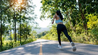 Akşamları dışarıda egzersiz yapan güzel bir kadının portresi, parkta koşan bir kadın, koşucular, tropik bir bahçede koşan atletler..