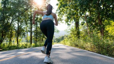 Akşamları dışarıda egzersiz yapan güzel bir kadının portresi, parkta koşan bir kadın, koşucular, tropik bir bahçede koşan atletler..