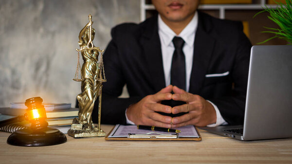 Attorney's office works on justice. businessman in suit or lawyer working on paperwork Legal concepts, advice, and justice, a judge with a hammer and scales, a laptop god.