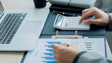 Bir muhasebeci, işadamı veya finans uzmanı, iş raporu grafiklerini ve bilgisayar çizelgelerini şirketin ofisinde analiz eder. Bankacılık ekonomisi konsepti. ve borsa araştırması