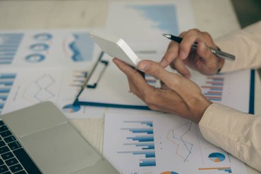 Bir muhasebeci, işadamı veya finans uzmanı, iş raporu grafiklerini ve bilgisayar çizelgelerini şirketin ofisinde analiz eder. Bankacılık ekonomisi konsepti. ve borsa araştırması