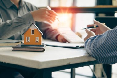 Satış temsilcileri, emlak acentelerinde sözleşme imzalamak için ev taksitleri ve ev alımları için faiz oranı sözleşmeleri sunuyor. mortgage konsept ev satın alma sözleşmesi