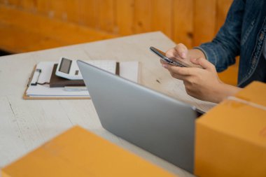 Küçük Girişimci, Girişim, KOBİ, Çalışmak için Genç Asyalılar ve Sevkiyat Konteynerleri çevrimiçi pazar yeri KOBİ 'si e-ticaret fikirlerini paketlediler ve evdeki dizüstü bilgisayarda müşteri siparişlerini kontrol ettiler.