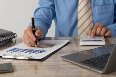 Hesap makinesine basmak, elinde kalem tutarken finansal belgeleri analiz etmek. Genç Asyalı işadamları vergi, fatura, ödeme için kredi kartı ve finansal konseptler alıyorlar.