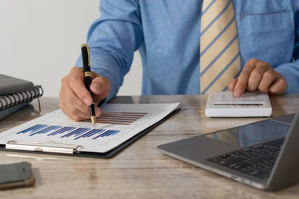 Hesap makinesine basmak, elinde kalem tutarken finansal belgeleri analiz etmek. Genç Asyalı işadamları vergi, fatura, ödeme için kredi kartı ve finansal konseptler alıyorlar.