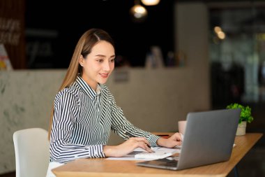 Bir iş analisti ya da muhasebeci mali belgeleri hesaplar ve inceler. Asyalı iş kadını dizüstü bilgisayarla tasarruf, finans ve ekonomi kavramını hesaplıyor.