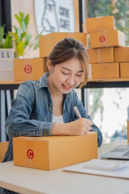 Küçük bir İşletme, KOBİ Sahipleri, Kadın Girişimciler fatura kutuları üzerinde çalışır ve nakliye kutularını hazırlamak için çevrimiçi siparişleri işaretlerler. KME müşterilerine çevrimiçi iş dünyasının dikey fotoğrafını sat