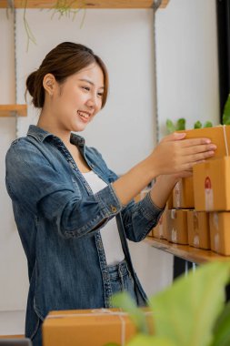 Küçük bir İşletme, KOBİ Sahipleri, Kadın Girişimciler fatura kutuları üzerinde çalışır ve nakliye kutularını hazırlamak için çevrimiçi siparişleri işaretlerler. KME müşterilerine çevrimiçi iş dünyasının dikey fotoğrafını sat