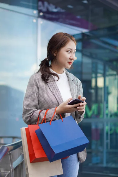 Młoda Kobieta Trzyma Torby Zakupy Przed Domem Towarowym Szczęśliwie Kupując — Zdjęcie stockowe