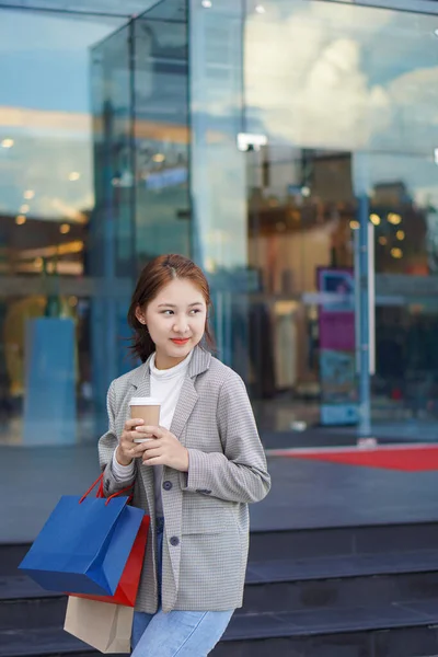 Una Mujer Joven Sostiene Bolsas Compras Frente Una Tienda Departamental —  Fotos de Stock