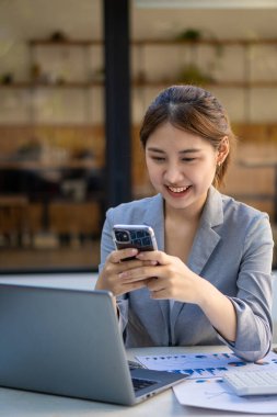 Genç bir kadın internetteki insanlarla bağlantı kurmak için akıllı telefon kullanıyor. Mesaj gönder ve internette dolaş. iletişim teknolojisi