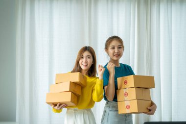 İş yerinde kutu ve dizüstü bilgisayarla çalışan Asyalı bir kadın, küçük işletme sahibi Girişimcilik, küçük işletme, KOBİ veya serbest internet üzerinden ve dağıtım fikirleri başlatıyor.