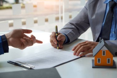 Satıcı, müşteri için inşa edilmek üzere olan bir ev örneğini tanımlıyor. Hem taksitler, hem faizler hem de emlak bürosu iş görüşmeleri fikirlerindeki sözleşme belgeleri