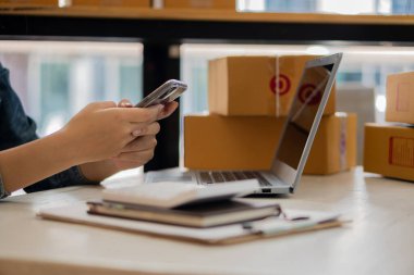 Küçük işletme girişimi Asya KOBİ Girişimcileri Kutu ve Smartphone Laptop Hesaplayıcıları ile çalışarak KOBİ pazarlama kavramının çevrimiçi pazarlama paketinden sipariş almakta