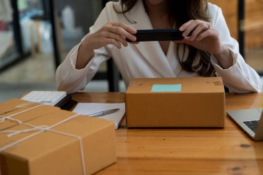 Küçük işletme girişimi Asya KOBİ Girişimcileri Kutu ve Smartphone Laptop Hesaplayıcıları ile çalışarak KOBİ pazarlama kavramının çevrimiçi pazarlama paketinden sipariş almakta