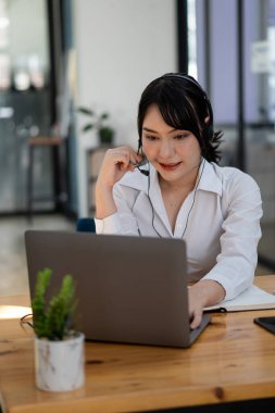 Asyalı kız öğrenciler çevrimiçi dil öğrenmek için kulaklık takarlar. Öğretmen videosunu izle ve dinle. Evde e-öğrenim denilen webinars adlı video dizüstü bilgisayara bakan uzaktan eğitim kızı kavramları.