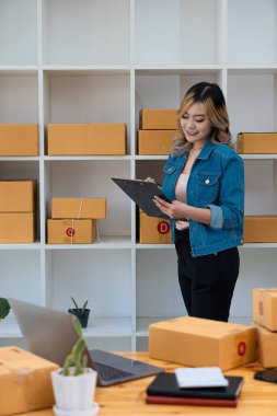 Genç İş Sahipleri Ev Sahipleri Çevrimiçi İş Fikirleri Girişimcilik Küçük İş KOBİ, kargo ürünlerine kutu hazırlamak için dizüstü bilgisayarlar kullanır ve kontrol eder. Satışlar