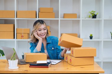 Genç İş Sahipleri Ev Sahipleri Çevrimiçi İş Fikirleri Girişimcilik Küçük İş KOBİ, kargo ürünlerine kutu hazırlamak için dizüstü bilgisayarlar kullanır ve kontrol eder. Satışlar