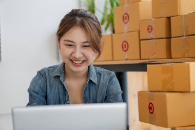 Genç İş Sahipleri Ev Sahipleri Çevrimiçi İş Fikirleri Girişimcilik Küçük İş KOBİ, kargo ürünlerine kutu hazırlamak için dizüstü bilgisayarlar kullanır ve kontrol eder. Satışlar