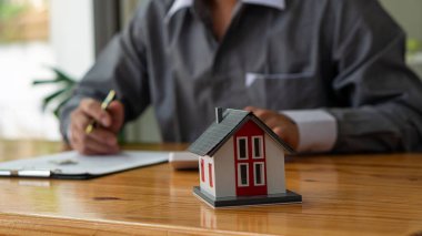 İşadamı, kontrat imzalayan ya da mali yatırımlarla uğraşan muhasebeci. bir hesap makinesi finansal belgeleri kullanarak raporu analiz ederek emlak ve ev kredisi sigortası