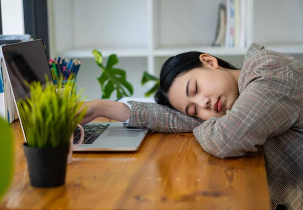 魅力的なアジアのビジネスマンの女性は 彼女の机で寝て または昼寝をしています 事務所の財務書類に疲れている会計士 表の財務チャートとノートパソコンは — ストック写真