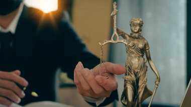 Avukatlık büroları yasal danışma masasında Adalet Tanrıçası 'nın çekiç ve terazisiyle kağıtlar ve kaplan derileri üzerinde çalışır..